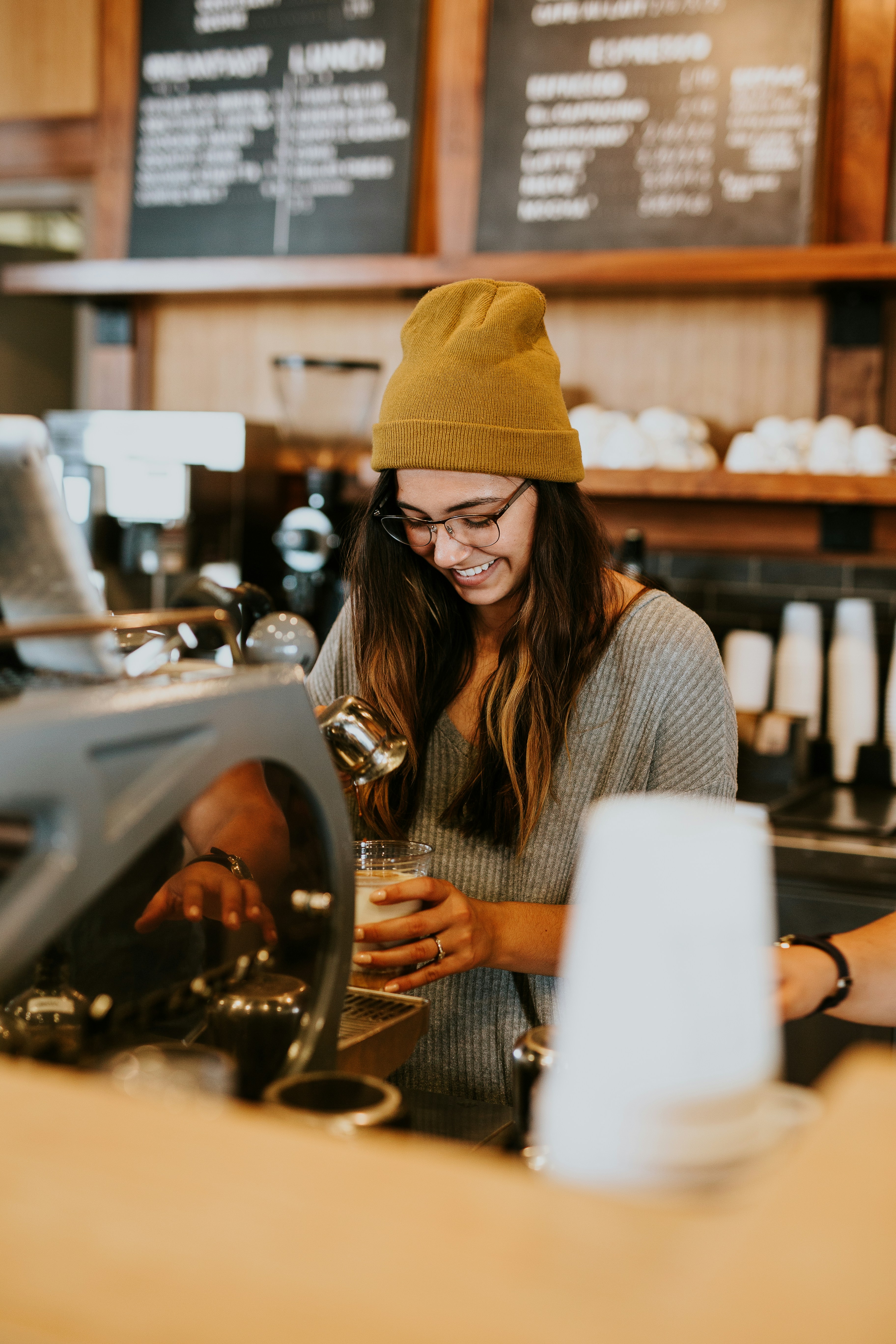 Smiling café owner preparing coffee, representing peace of mind from having a website handled